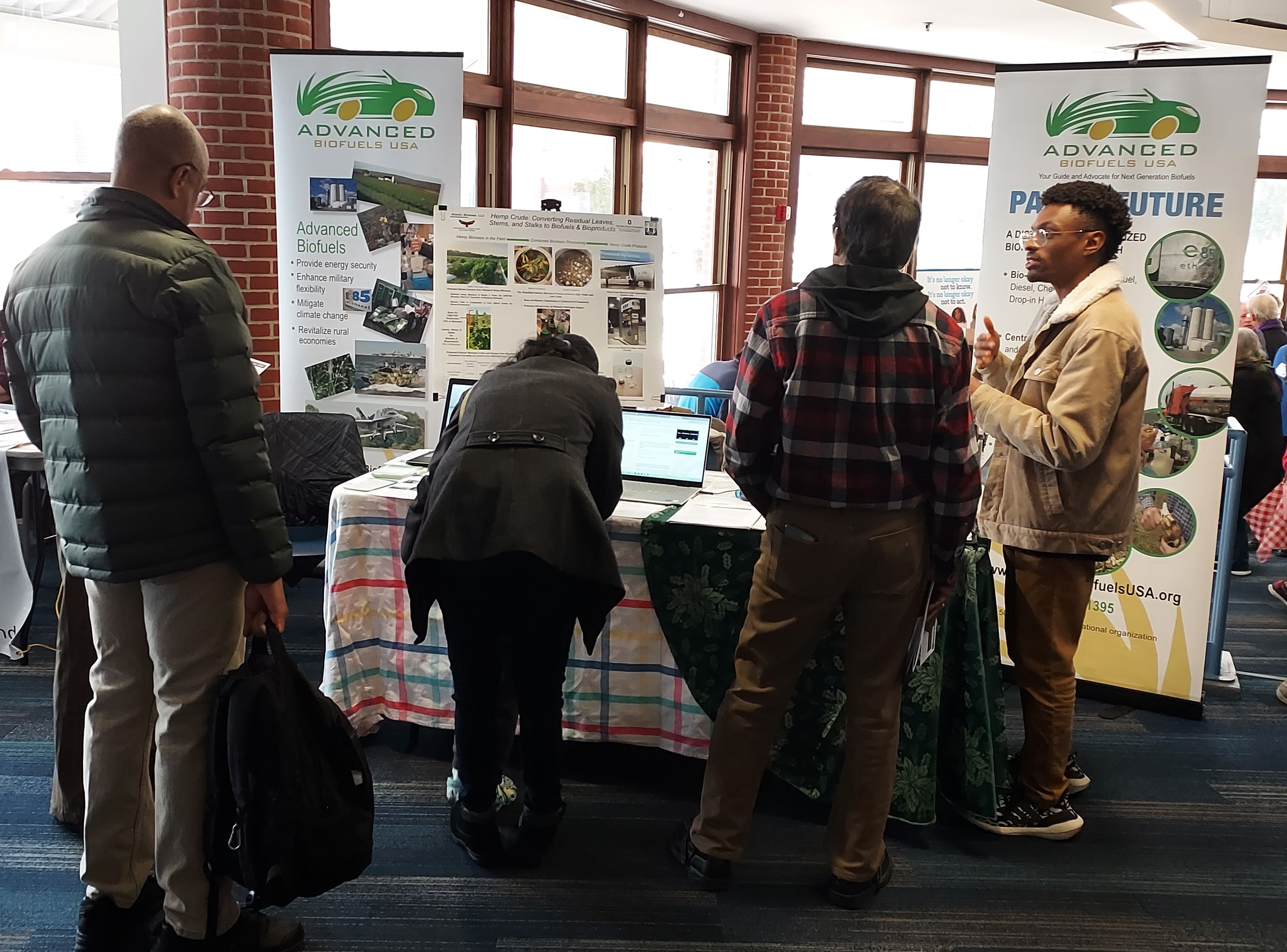 Justin McPHerson explains renewable fuels to visitors at the Advanced Biofuels USA information table at Mobilize Frederick's Climate Summit